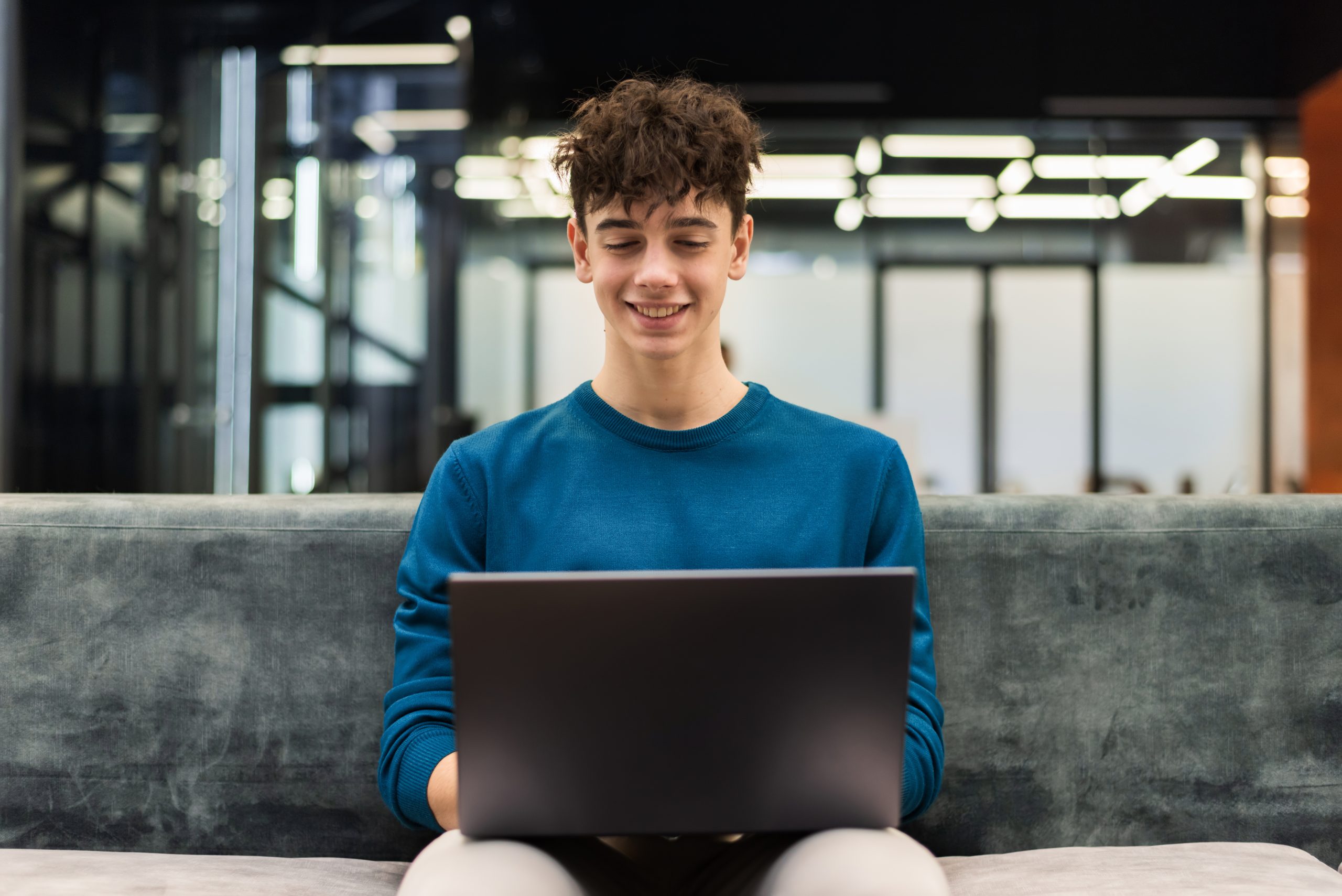 Young smiling man working with a laptop in an office